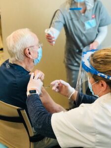 A senior man receives a covid vaccine.