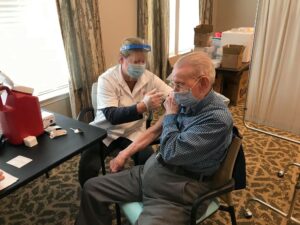 A senior man receives a covid vaccine.