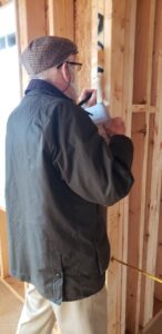 A resident writing scripture on wood framing of The Culpeper's new senior living cottages.