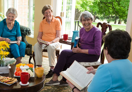 Seniors gather in a home for a book club meeting